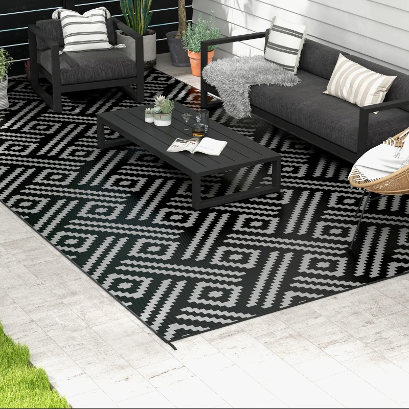 Tapis noir et blanc à motifs dans un espace extérieur moderne avec mobilier.