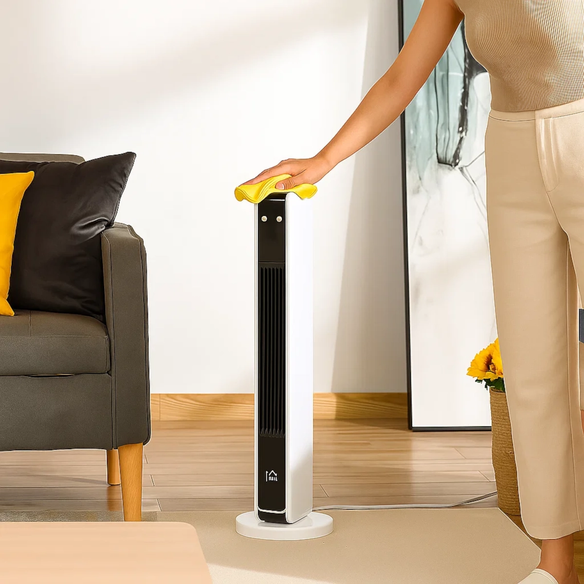 Le dessus d'un radiateur tour blanc en cours de nettoyage avec un chiffon dans un salon moderne.