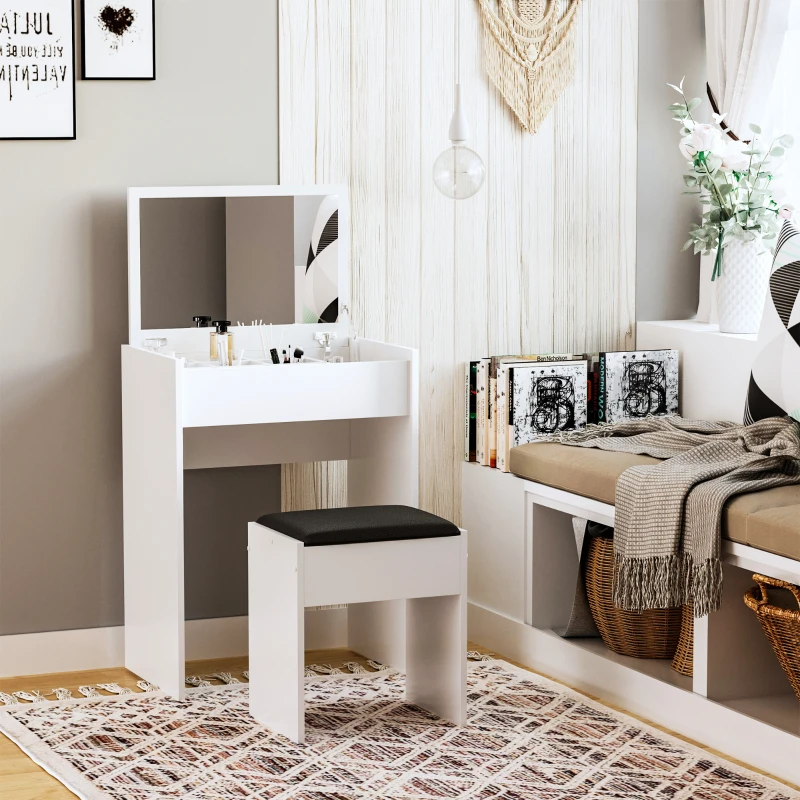Coiffeuse blanche et compacte avec miroir à rangement dissimulé et tabouret, positionnée dans un coin lumineux et minimaliste avec des livres.
