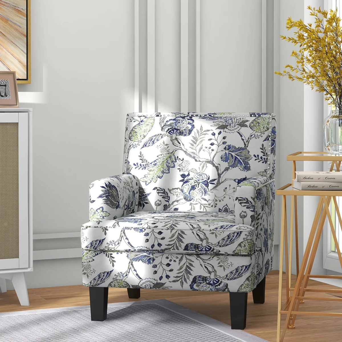 Fauteuil d'appoint à motifs floraux avec des accoudoirs roulés à côté d'une table d'appoint dorée et de livres décoratifs.