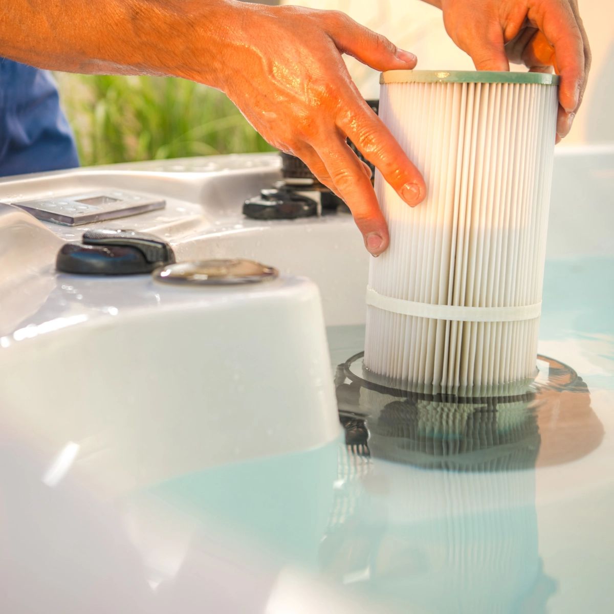 Des mains remplacent la cartouche du filtre d'eau dans un bain de plongée froide pour une circulation d'eau propre.