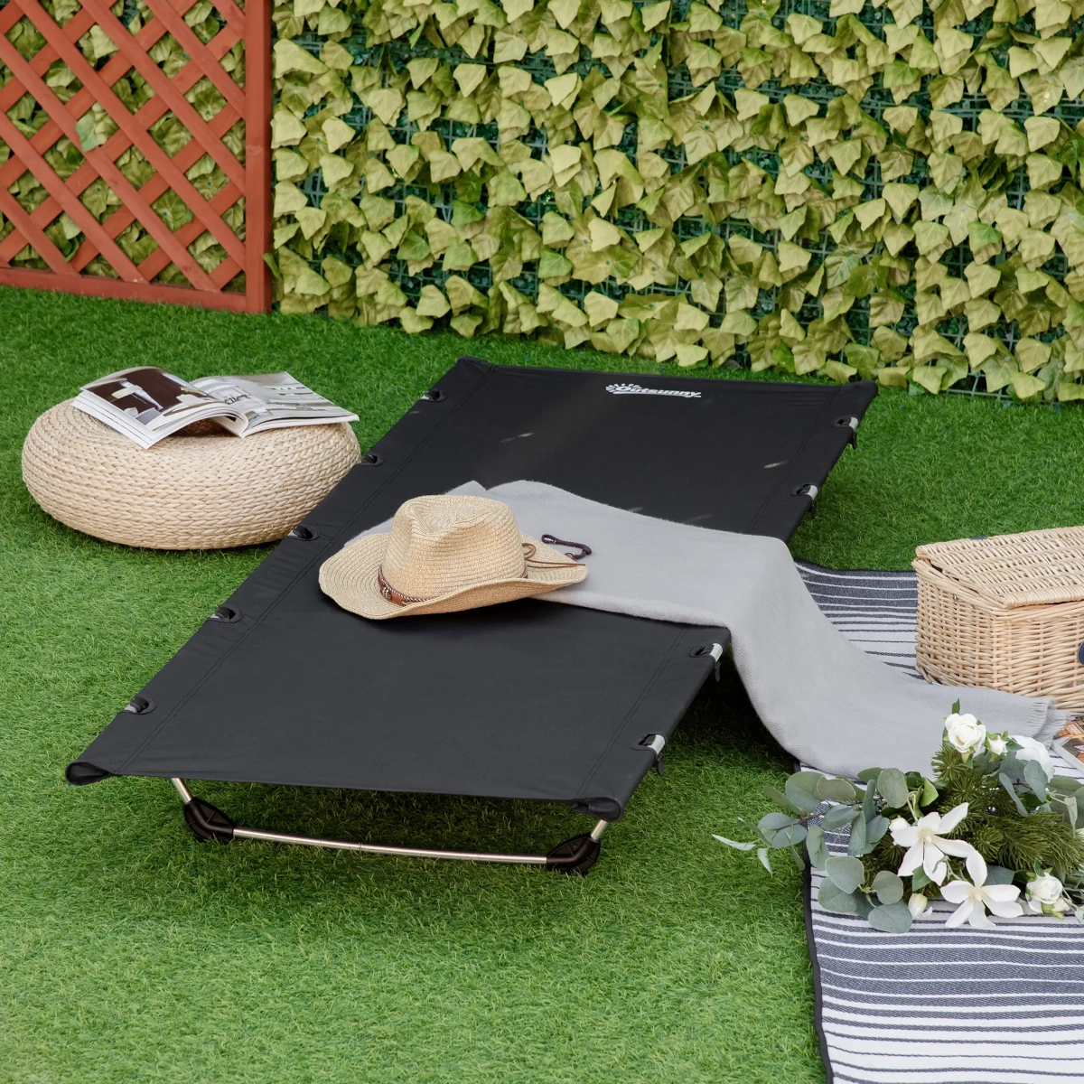 Lit de camping fin et surélevé en aluminium avec tissu respirant placé sur un terrain rocheux en extérieur.