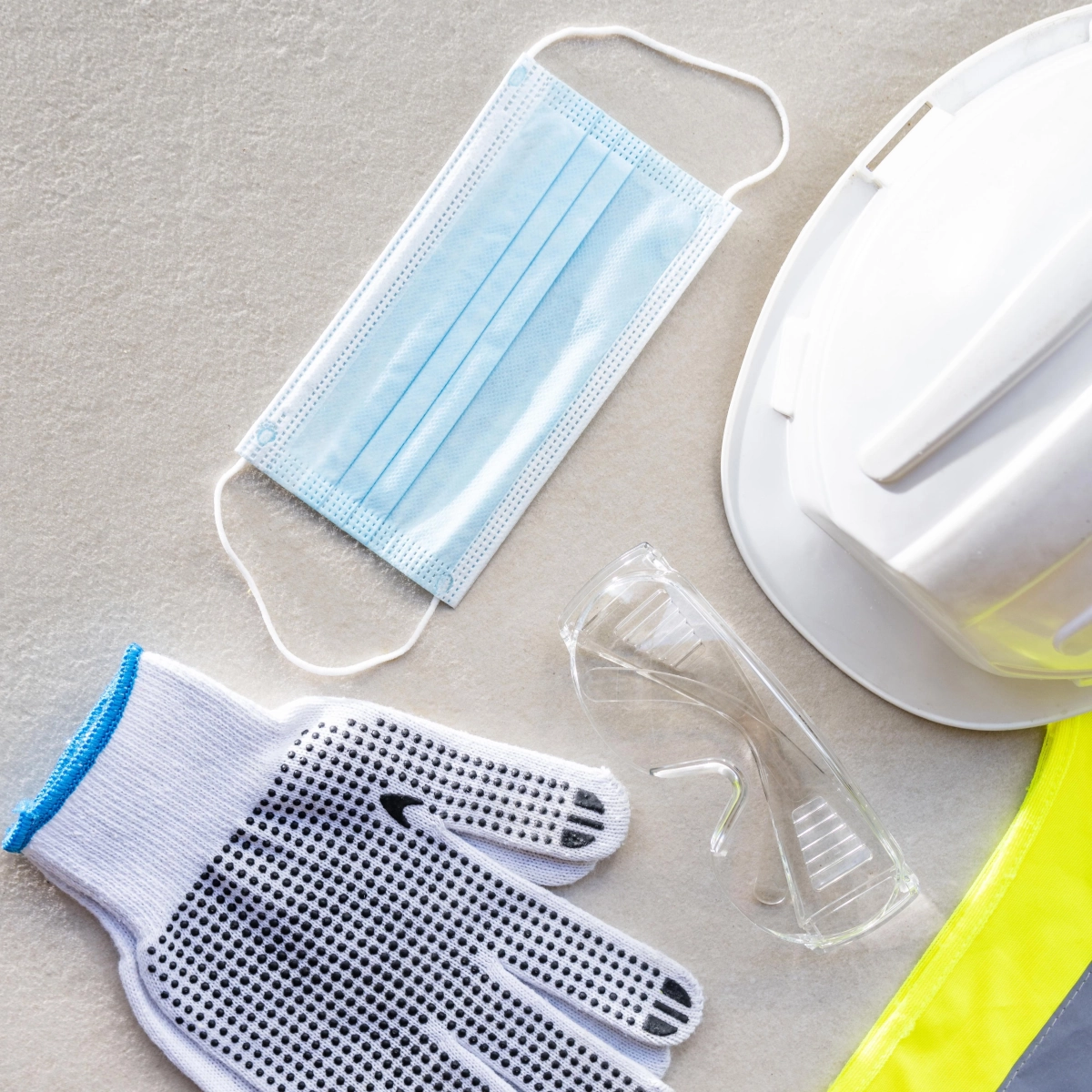 Peintre portant des gants, des lunettes de protection et un masque en préparation pour peindre en extérieur.