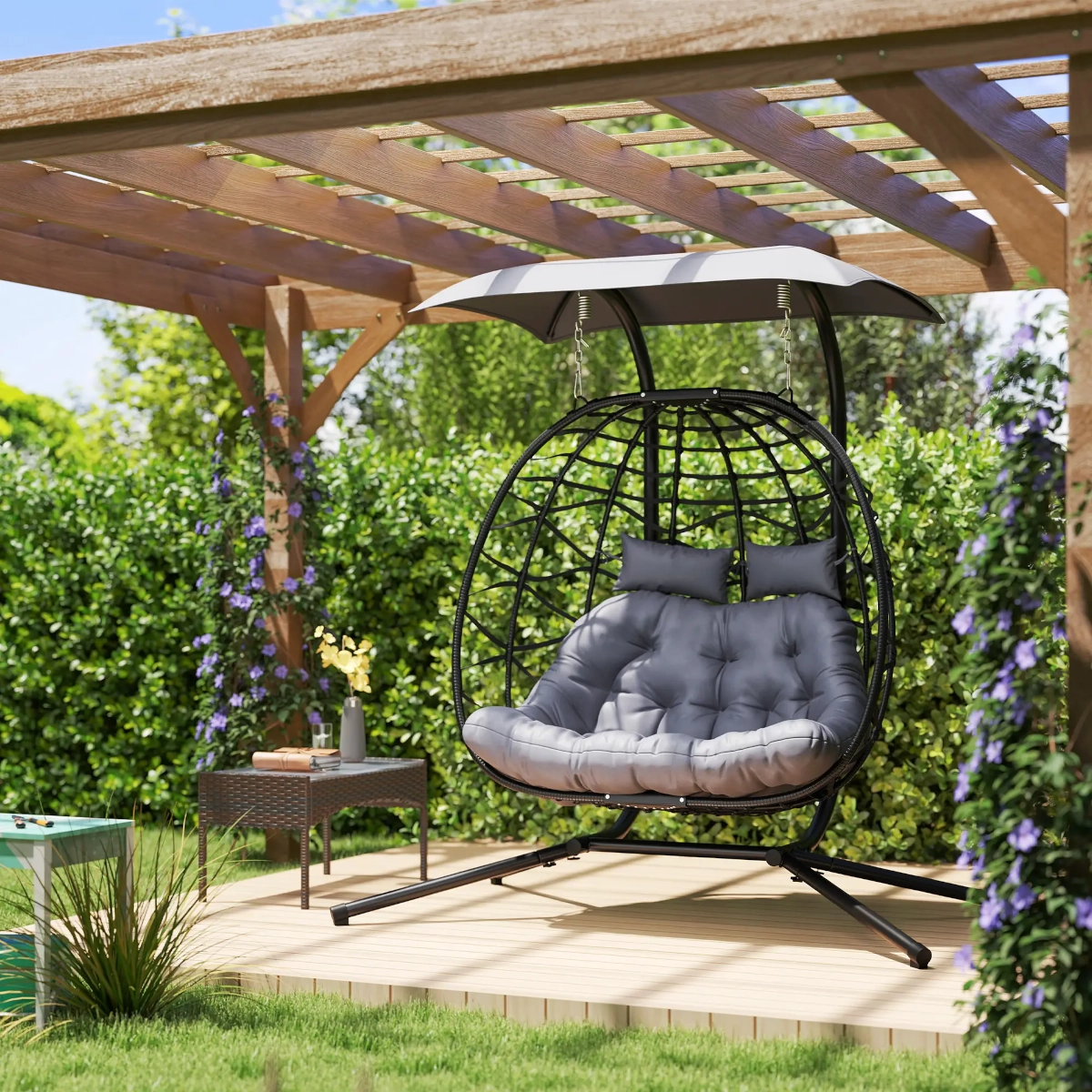 Fauteuil balançoire œuf double extérieur avec auvent et coussins pour une détente ombragée dans le jardin.
