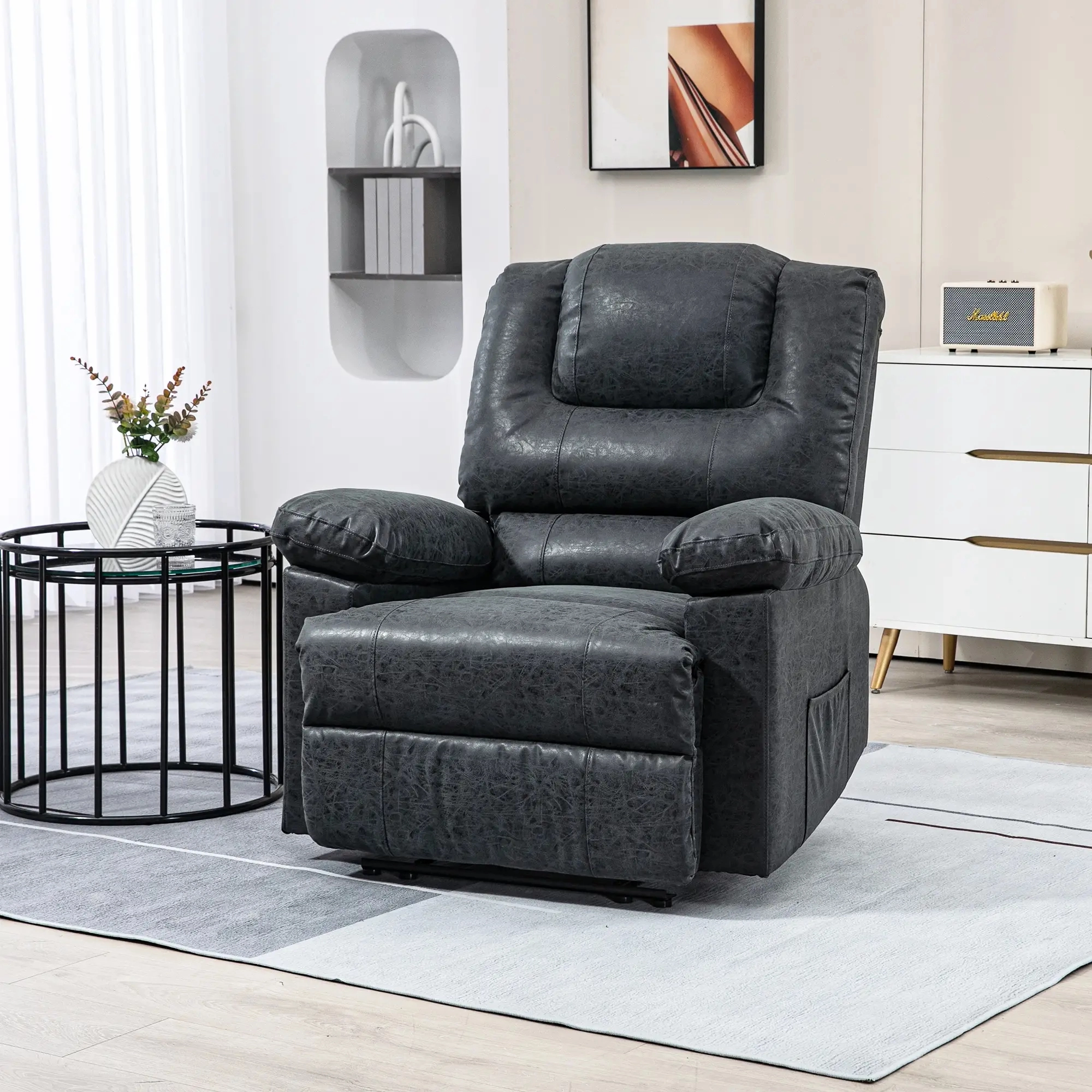 Fauteuil inclinable moelleux en cuir noir dans une pièce lumineuse avec une table d'appoint ronde en métal noir.