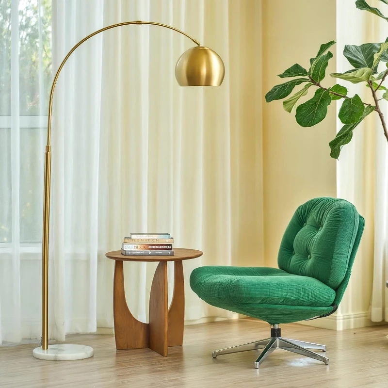 Salon moderne avec lampadaire arqué doré doté d’un pied en marbre à côté d’un fauteuil vert et d’une table.